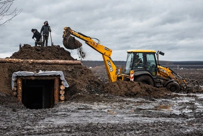 A female employee of a sushi restaurant digs defensive fortifications in Kharkiv