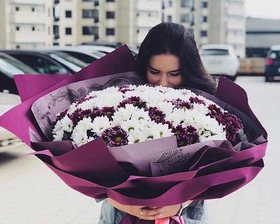 Man presents bouquet of red roses