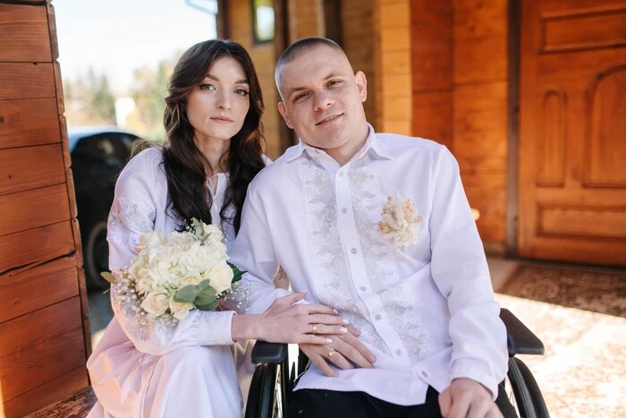 A girl holds the hand of her military boyfriend in the intensive care unit